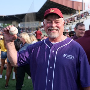 Individual Posing for a Picture at a Baseball Game